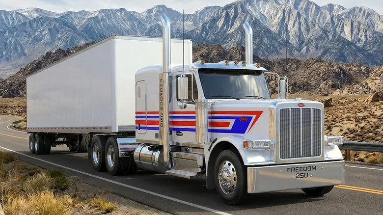 Front 3/4 view of Peterbilt Freedom 250 Special Edition Model 589 pulling a freight trailer