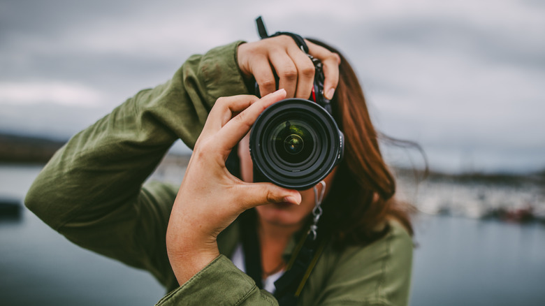 woman taking photos facing a camera