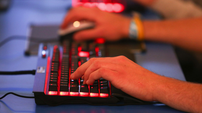 gamer playing on a computer with a keyboard and mouse