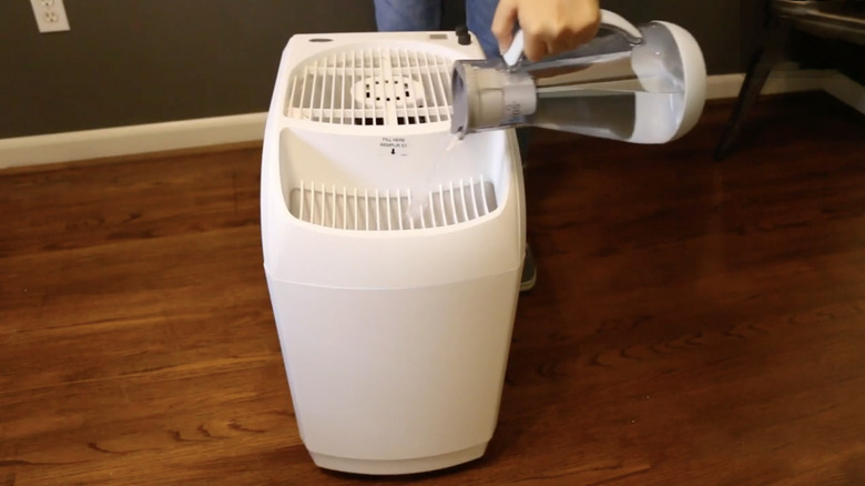 Refilling the Aircare 6 Gal. Whole House Humidifier with a water pitcher.
