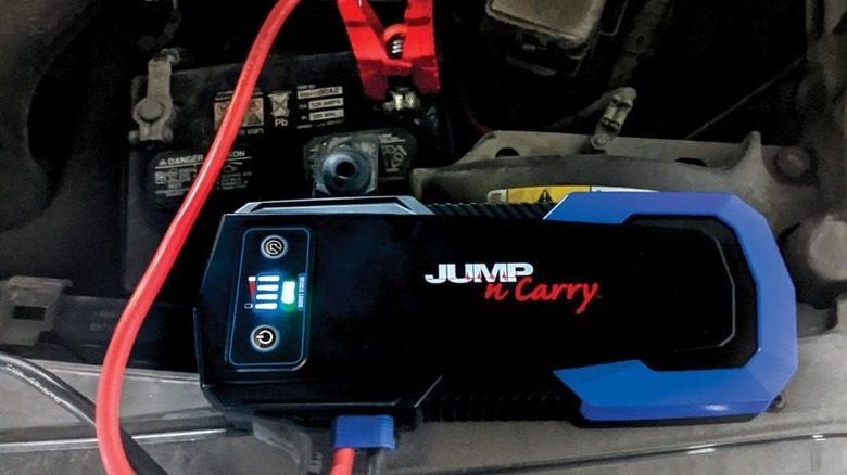 jump starter with clamps attached to battery