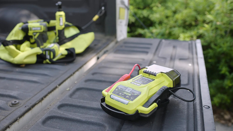 Ryobi jump starter resting on an open truck tailgate