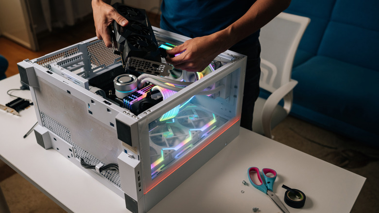 computer technician installing new graphics card into custom-built pc