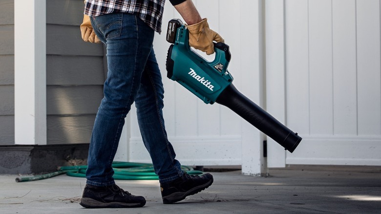 A person using a Makita blower outside.