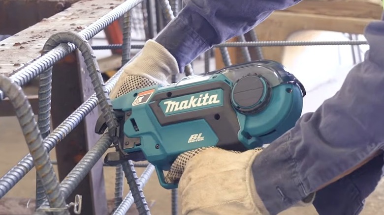 A worker using a Makita 18V LXT cordless rebar tying tool