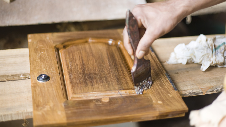 person finishing cabinet door