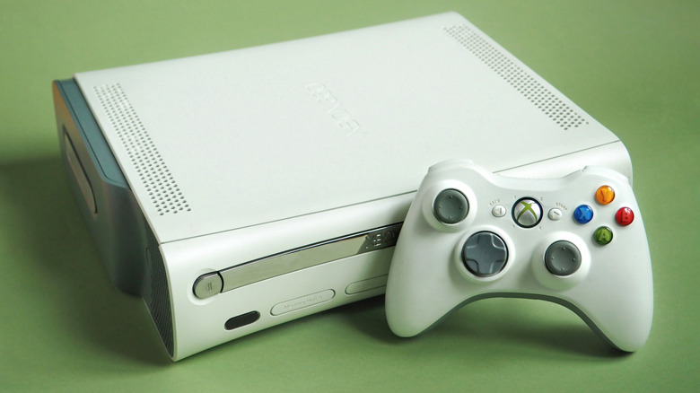 An Xbox 360 console and controller against a green background.
