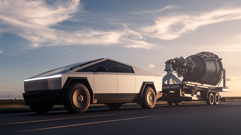 Front 3/4 view of Tesla Cybertruck towing trailer with rocket parts.