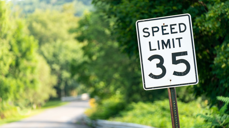 A sign showing a 35 miles per hour speed limit on a rural road.