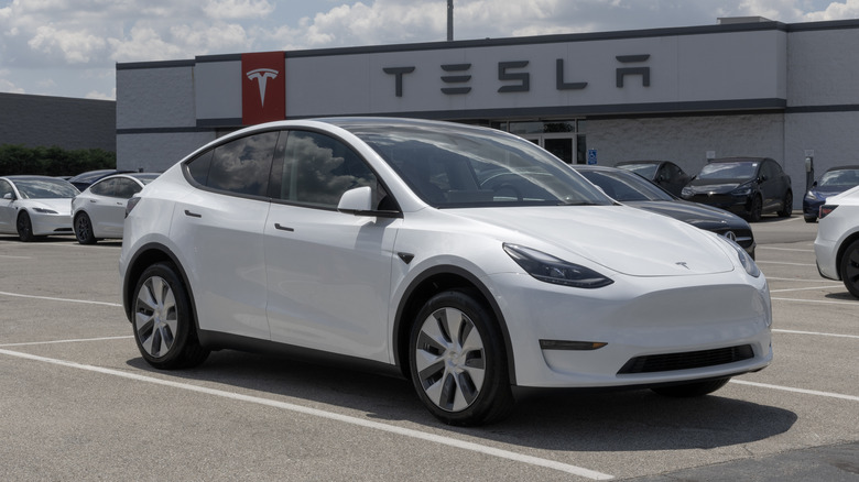 A Tesla Model Y parked outside a Tesla store