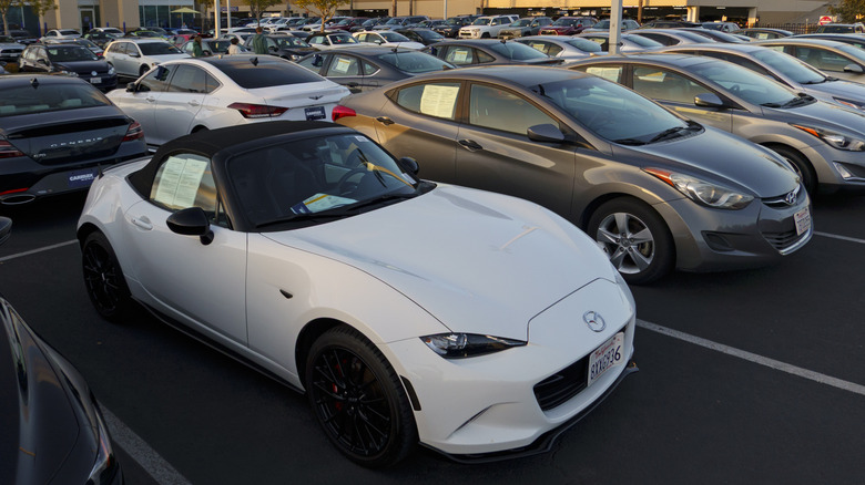 Overhead view of white Mazda MX-5 Miata parked on CarMax dealership lot.