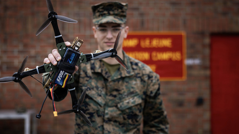 Marine Sergeant Henry David Volpe holding up HANX drone outside Camp Lejeune innovation campus