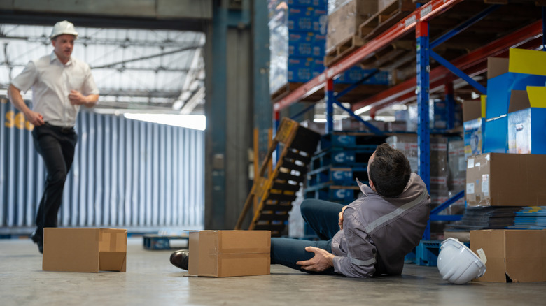 Warehouse worker approaching injured man