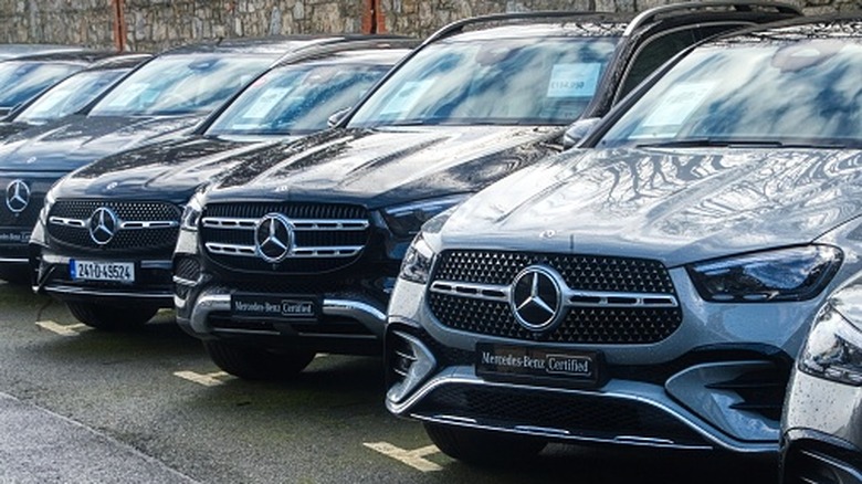 A Mercedes-Benz dealership with a line of vehicles for sale