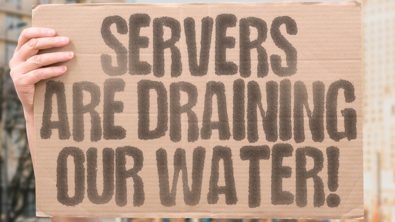A protestor hold up a sign targeted at the water use of data centers.