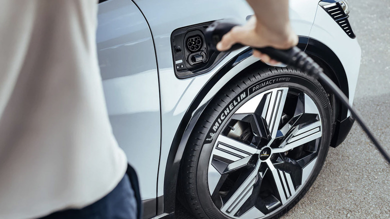 View of man charging EV that has Michelin Primacy 5 Energy tires.