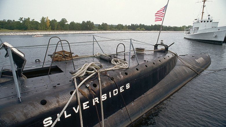 Rear view of USS Silversides submarine ship with American flag flying.