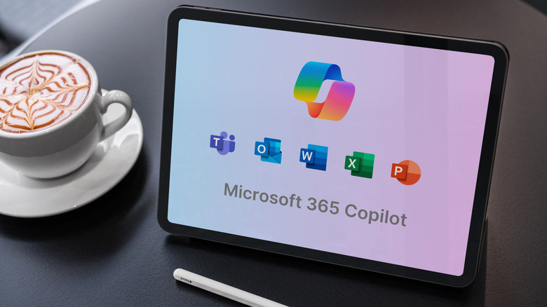 A tablet with various Microsoft 365 Copilot logos on it, next to a cup of coffee.