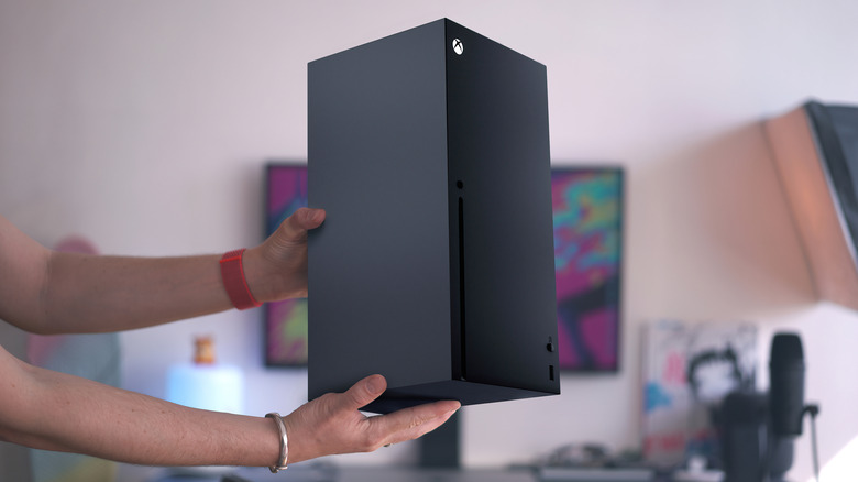 Someone holding xbox series x console