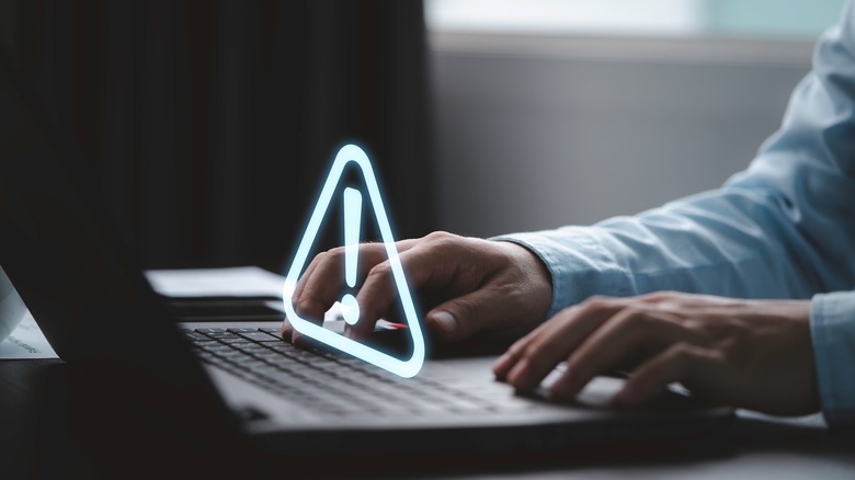 Laptop with exclamation point hovering above keyboard