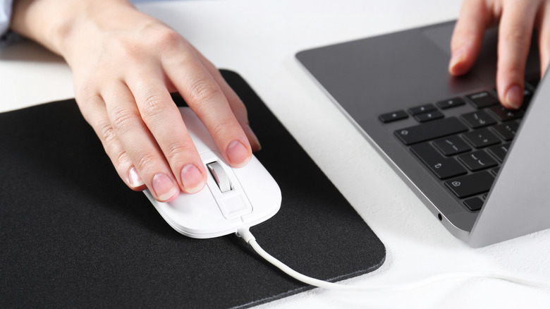 Woman using computer mouse with Macbook Air