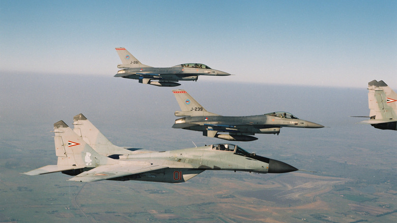 A two F-16s of the Dutch 313 Squadron and two MiG-29s of the Hungarian Air Force fly in formation.