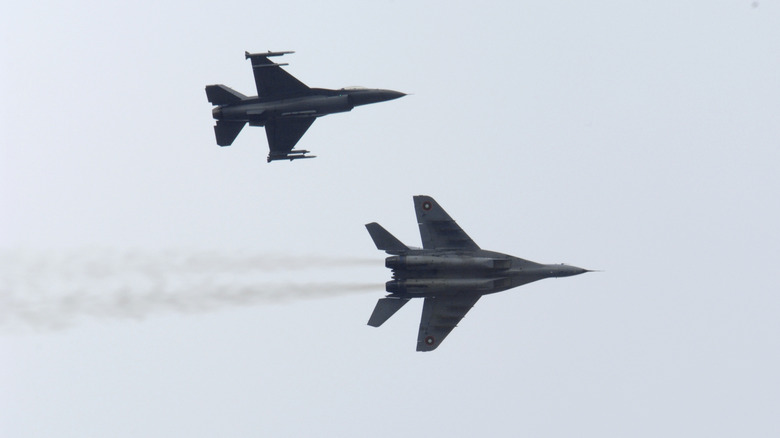 An F-16 Fighting Falcon, top, and a MiG-29 Fulcrum aircraft sky over Graf Ignatievo Air Base, Bulgaria, during exercise Nickel Javelin in 2008.