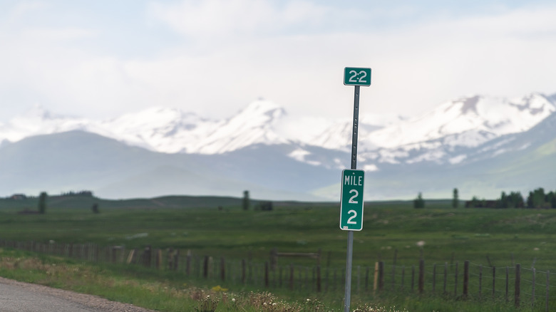 Green mile marker sign on side of highway