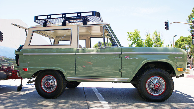 a green vintage Ford bronco with roof rack