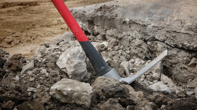 a Milwaukee mattock sitting in concrete debris