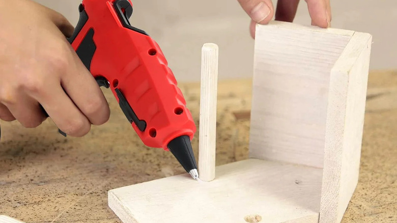 person using a Livowalny cordless hot glue gun to make a birdhouse