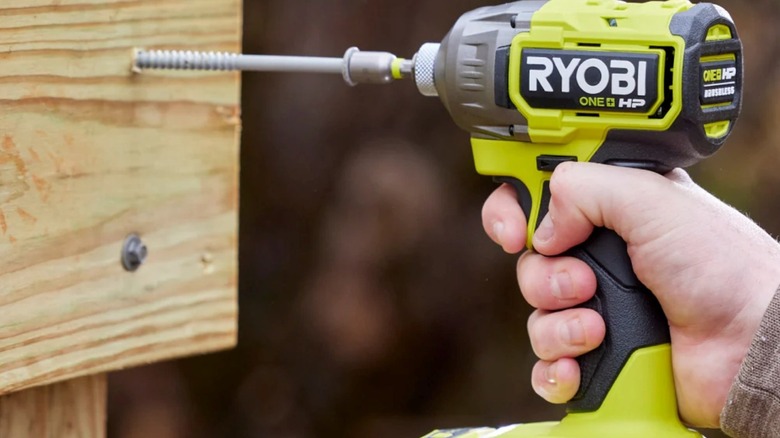 Ryobi's 18V One+ impact driver driving a long lag bolt into wood.