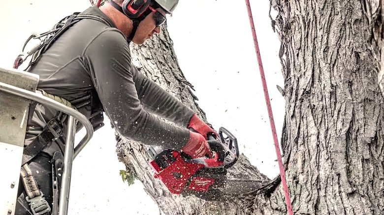 Person using Milwaukee M18 Chainsaw