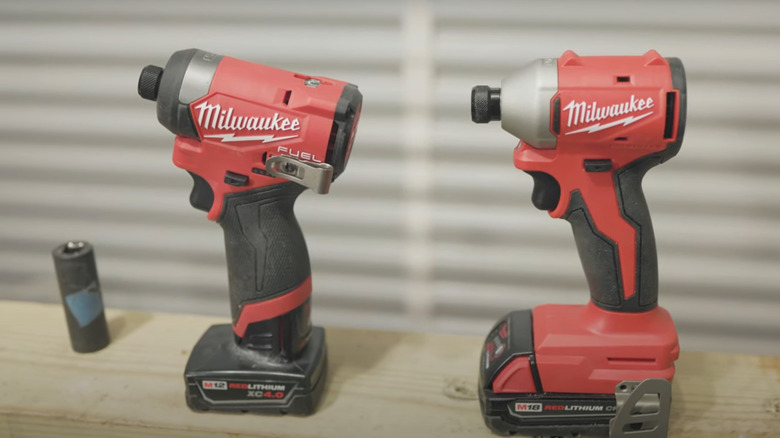 M12 and M18 Milwaukee Impact Drivers on wooden table