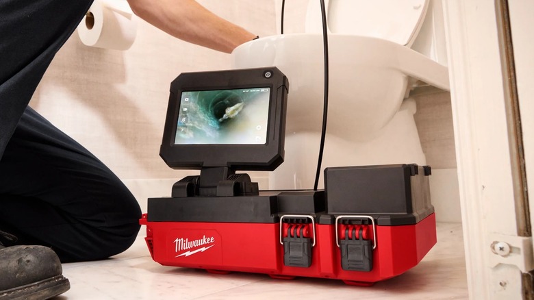 A person using a Milwaukee Packout drain camera