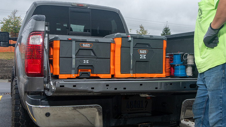 A worker loads Klein Tools cases into a pickup truck