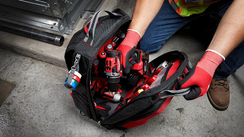 man getting tools from Milwaukee backpack