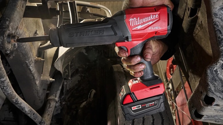 A person using a Milwaukee cordless chisel hammer.