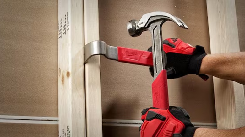 using a Milwaukee hammer and prybar together on boards