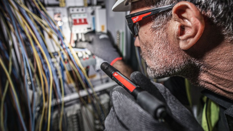 using a Milwaukee penlight to see wiring in the dark