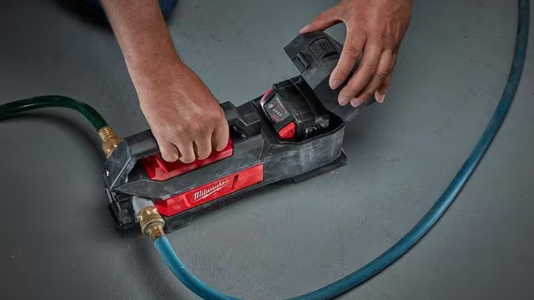 Opening the battery cover on a Milwaukee Transfer Pump