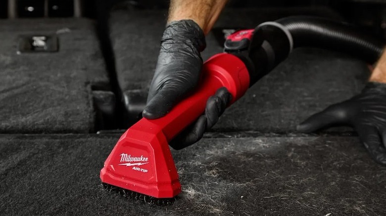 Person cleaning vehicle with Air-Tip Automotive Detail Brush