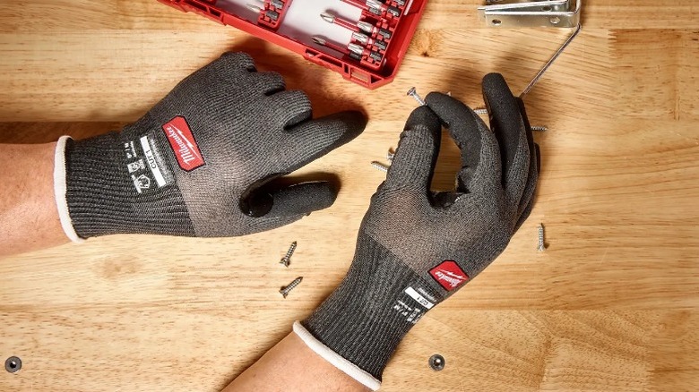 Person holding nail using Cut Level 1 Nitrile Dipped Gloves with Wear Defense