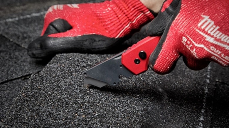 Person using a Milwaukee Fastback Utility Knife