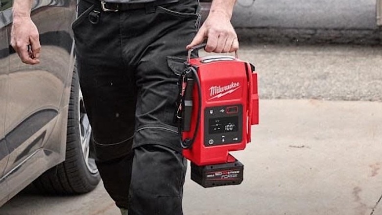 Person carrying a Milwaukee Hot Shot Jump Starter