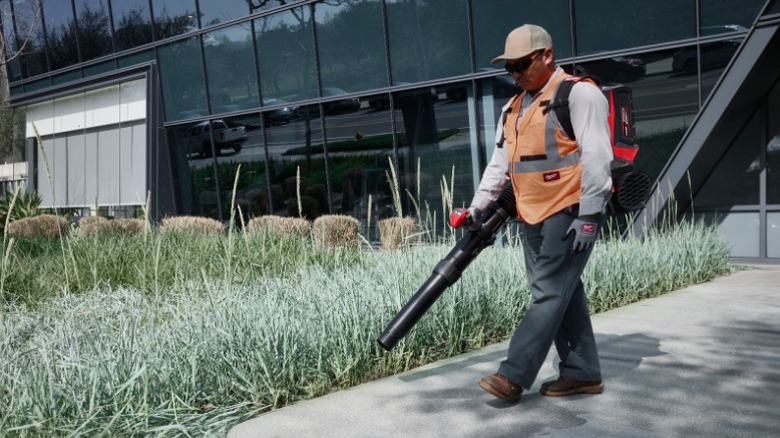 Man using MX Fuel Backpack Blower on curbside