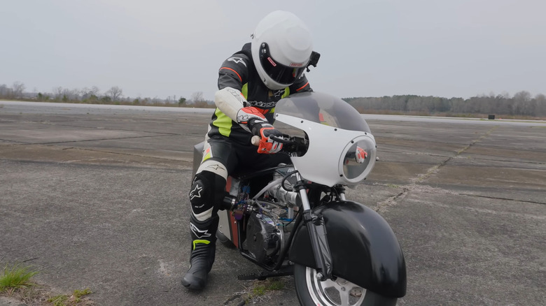 A biker on a modded mini bike on an airport runway