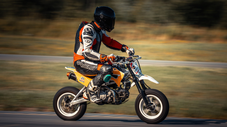 A racer speeds down a countryside track on a pit bike