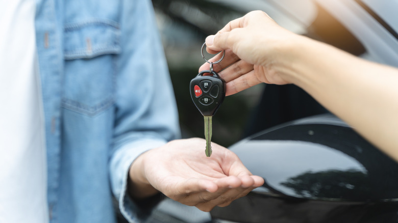 A person getting the key after buying a car.