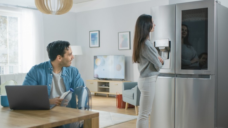 Woman and man looking at smart fridge